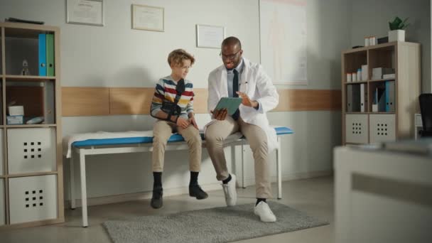 Doctor praat met Young Boy met gebroken arm in het ziekenhuis — Stockvideo