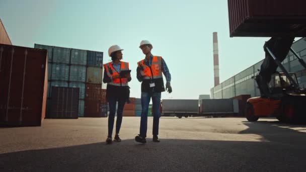 Ingenieros industriales caminan en la terminal de contenedores — Vídeo de stock