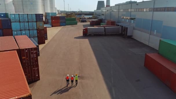 Βιομηχανικοί μηχανικοί περπατούν στον τερματικό σταθμό εμπορευματοκιβωτίων — Αρχείο Βίντεο