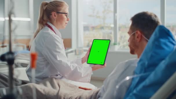 Врач отделения больницы с помощью планшетного компьютера и пациента в постели — стоковое видео