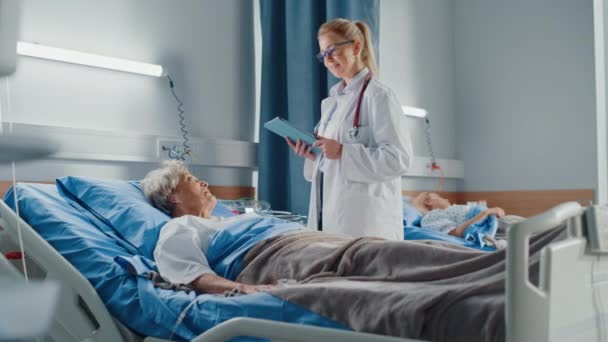 Médico de la sala del hospital habla con paciente en la cama — Vídeos de Stock