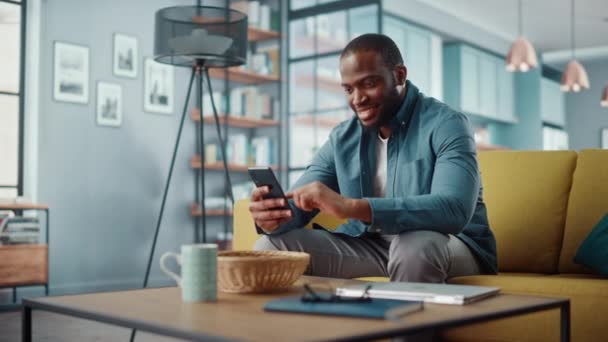 Hombre con Smartphone sentado en la sala de estar — Vídeo de stock