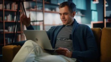 Oturma odasında dizüstü bilgisayarı olan bir erkek.