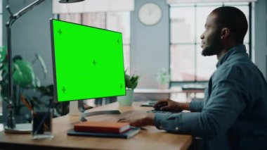 Oturma odasında Yeşil Ekran ile Masaüstü Bilgisayarında Çalışan Erkek