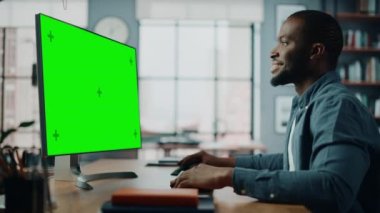 Oturma odasında Yeşil Ekran ile Masaüstü Bilgisayarında Çalışan Erkek