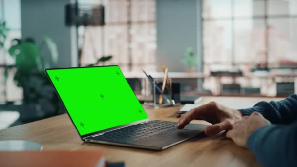 Man werkt op laptop met groen scherm in de woonkamer — Stockvideo