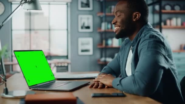 Maschio in videochiamata sul computer portatile con schermo verde in salotto — Video Stock