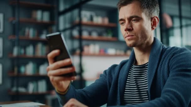 Muž se smartphonem Sedící v obývacím pokoji — Stock video