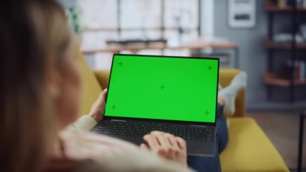 Женщина с ноутбуком с зеленым экраном в гостиной — стоковое видео