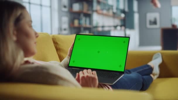 Female Using Laptop with Green Screen in Living Room — Stock Video