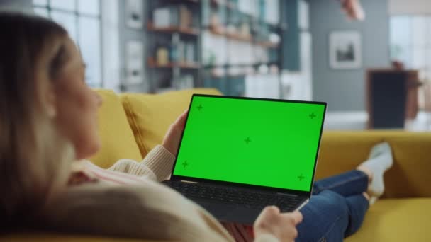 女性在客厅使用带绿色屏风的笔记本电脑 — 图库视频影像