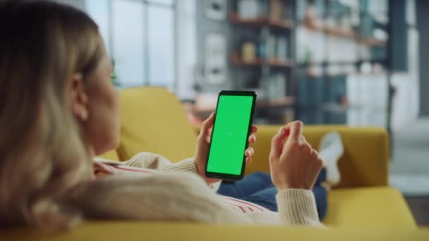 女性在客厅使用带绿色屏风的智能手机 — 图库视频影像