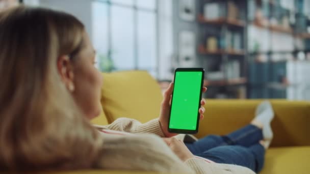 Жіночий смартфон з зеленим екраном у вітальні — стокове відео