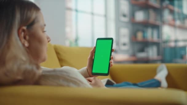 Femeie care utilizează smartphone cu ecran verde în camera de zi — Videoclip de stoc