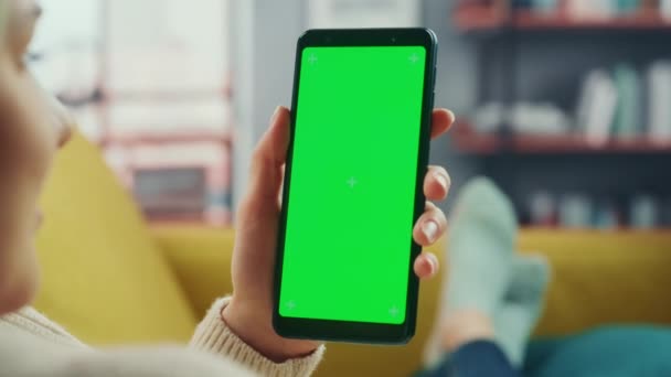 Žena pomocí Smartphone se zelenou obrazovkou v obývacím pokoji — Stock video