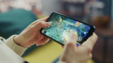 Oturma odasında Smartphone 'da Kadın Strateji Oyunu
