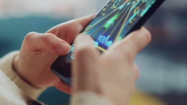 Жінка грає в аркадні ігри на смартфоні у вітальні — стокове відео