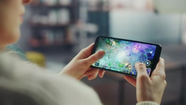 Vrouwelijke spelen Strategie Game op Smartphone in de woonkamer — Stockvideo