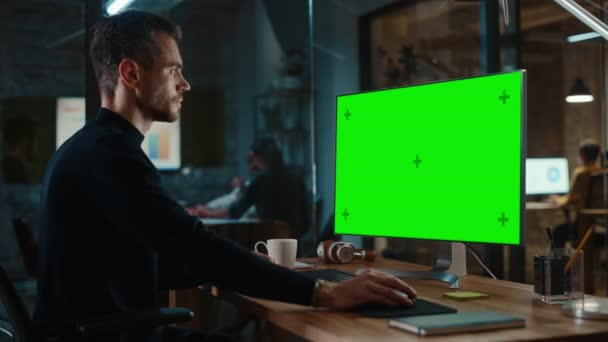 Man Works on Computer with Green Screen in Creative Office — Stock video