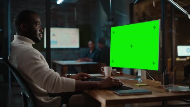 Black Man Works on Computer with Green Screen in Creative Office — 비디오