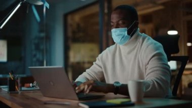 Yüz Maskeli Siyah Adam Laptopta Çalışıyor