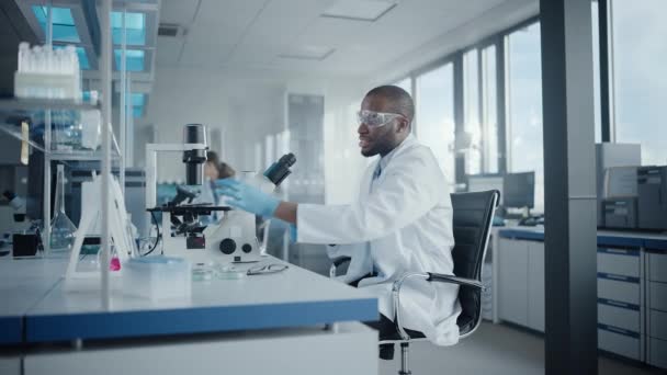 Medische Laboratoriumwetenschapper met behulp van microscoop — Stockvideo