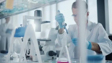 Mikroskop kullanan büyük bir tıp laboratuarı bilimcisi.