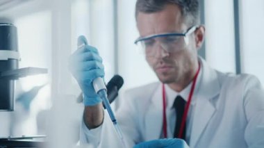 Mikroskop kullanan büyük bir tıp laboratuarı bilimcisi.