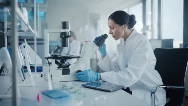 Kobieta naukowiec patrząc pod mikroskopem w laboratorium — Wideo stockowe