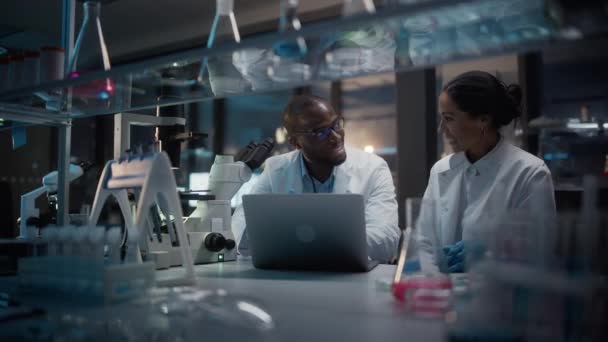 Två forskare som arbetar i laboratoriet på natten. — Stockvideo