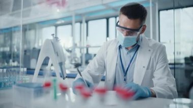 erkek bilim adamı laboratuarda çalışıyor.