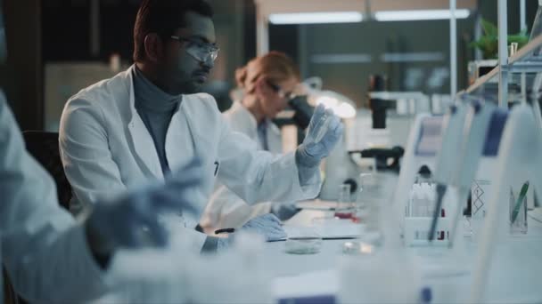 Ученые разных команд работают в лабораториях — стоковое видео