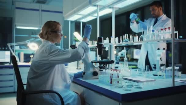 Wetenschapper die Microscoop in Laboratorium gebruikt — Stockvideo