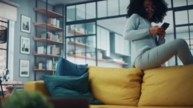 Smartphone ile Kanepeye Zıplayan Mutlu Latin Kadın