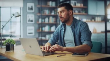 Dizüstü bilgisayarlı erkek Oturma odasında oturuyor