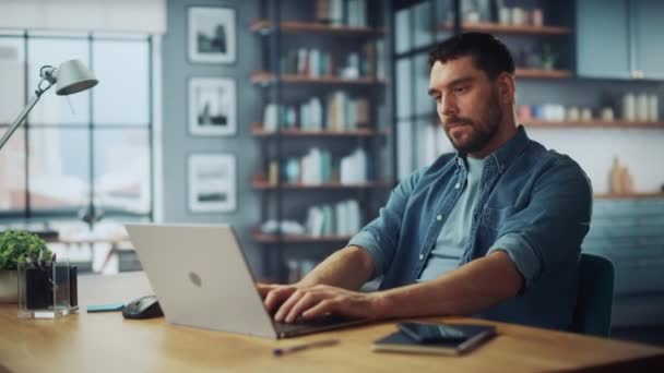 Man met laptop zit in de woonkamer — Stockvideo