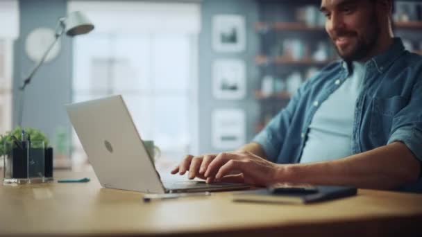 Man met laptop zit in de woonkamer — Stockvideo