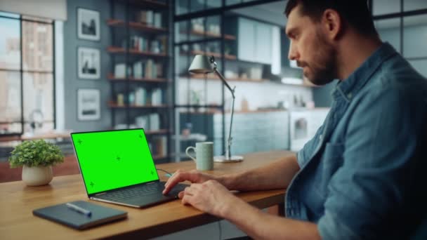 Male Using Laptop with Green Screen in Living Room — Stock Video