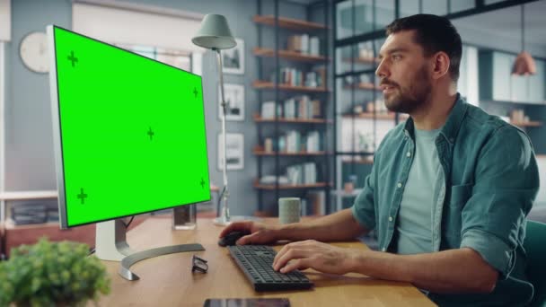 Muž pomocí počítače se zelenou obrazovkou v obývacím pokoji — Stock video