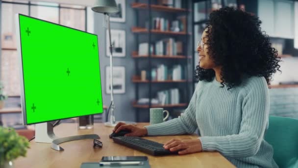 Weibchen nutzen Computer mit grünem Bildschirm im Wohnzimmer — Stockvideo