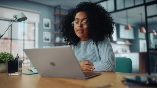 Женщина на видео-вызове на ноутбуке в гостиной — стоковое видео
