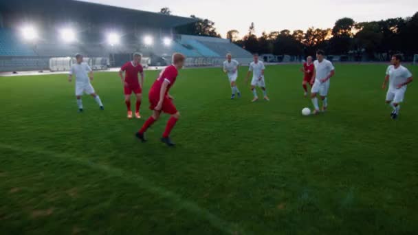 Панорамний знімок команди футболістів, які ведуть з м'ячем граючи проходять активні атакуючі цілі опонентів — стокове відео