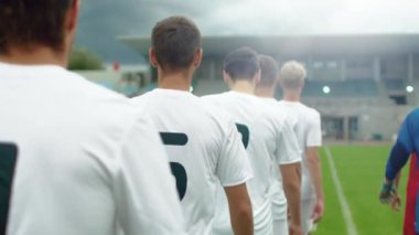 Two Soccer Teams Walk onto the Football Field