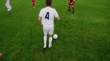 Following Elevated Soccer Player Leads with Ball Dribbling Around Rivalring Team Players