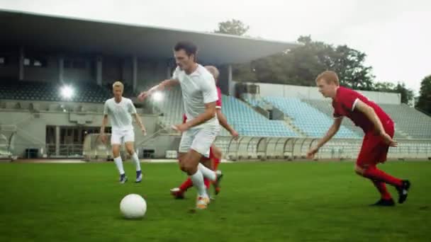 En el estadio de fútbol atacando al jugador Dribbles Ball alrededor de sus rivales y da un pase — Vídeos de Stock