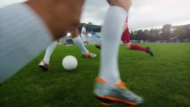 Low Ground Following Shot of Soccer Player Liderando com bola driblando em torno de jogadores da equipe rival — Vídeo de Stock