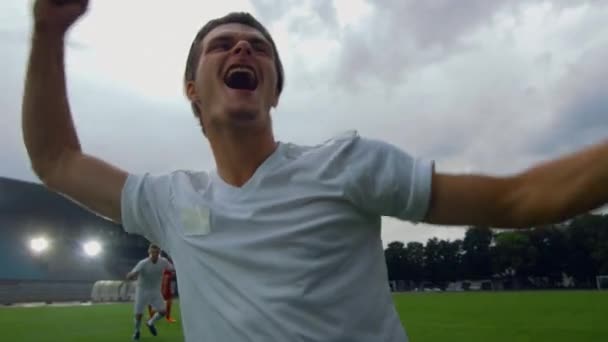 En el estadio de fútbol Los jugadores de fútbol se desliza en el campo y hace Gesto ganador después de la meta — Vídeos de Stock