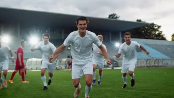 On Soccer Stadium Football játékosok siklás a pályán, és hogy győztes gesztus után Goal — Stock videók