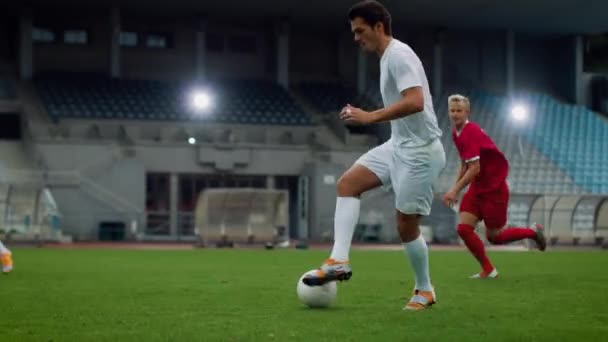 Energisk fotboll spelare leder med bollen Dribbling runt rivaliserande lagspelare på fotbollsplan — Stockvideo