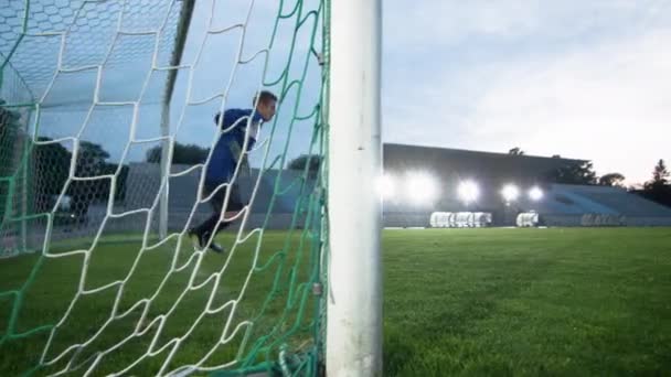 Vue latérale Gardien de but de soccer saute et rate ballon volant dans les buts — Video